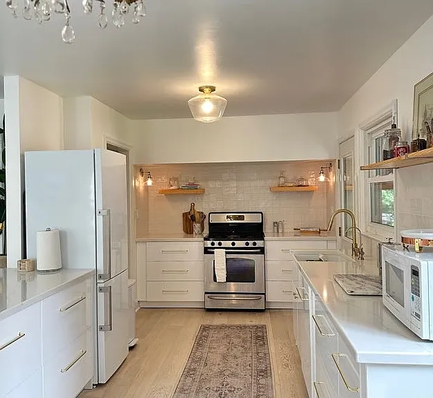Main level kitchen with soft-close drawers, gas range and oven, discreet dishwasher, garbage disposal (in sink), quartz countertops, and filtered drinking water.