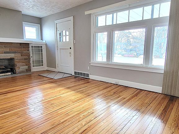 freshly refinished hardwood floors and beautiful character in the fireplace flanked by built-in cabinets