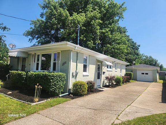 Side view of house with driveway and garage.