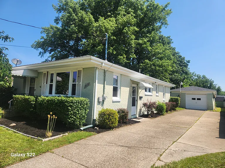 Side view of house with driveway and garage.