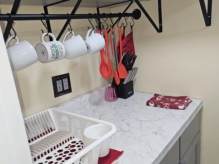 Kitchen area with plates, glass cups and utensils