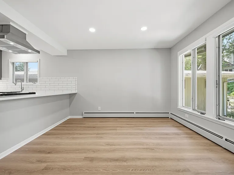 Wall of ceiling-to-floor windows overlooking mature back yard
