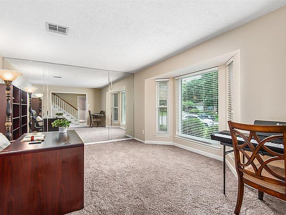 Formal living room could easily be used as a study! This room features a beautiful bay window and floor-to-ceiling mirrored wall.