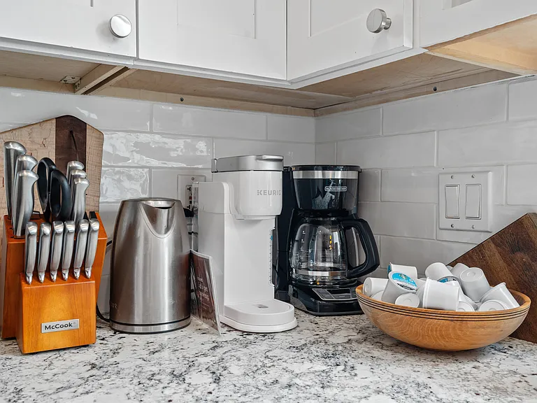 Sunlight streams through large windows, illuminating the space and highlighting the gleaming surfaces.
Whether you're a fan of the convenience and variety of Keurig's single-serve pods or prefer the timeless ritual of brewing a pot of drip coffee, both op