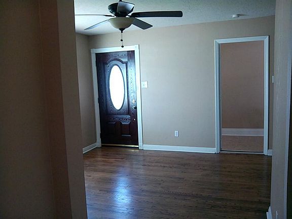 Another view of living room and front door from the hallway