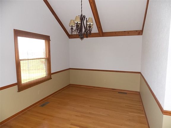 Formal Dining room with hardwood floor and vaulted ceiling.