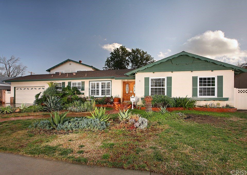 The meticulous landscaping, colorful raised brick