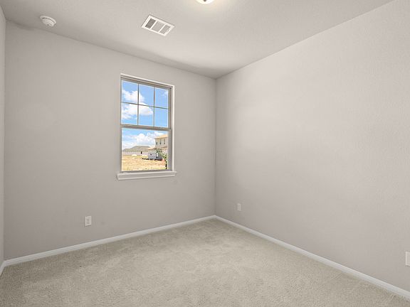 The third bedroom features plush carpet, neutral paint, large windows and access to the Jack and Jil