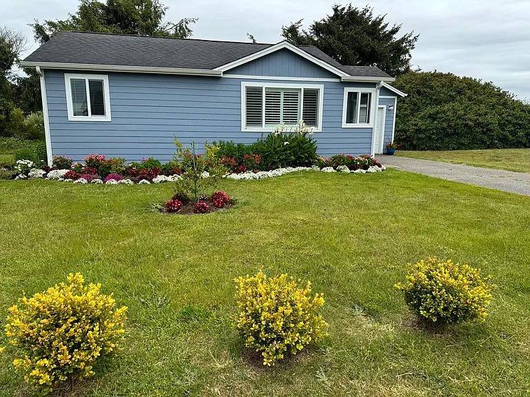 Garfield Avenue Side of the Cottage. Blooming gardens with a variety of flowers_.Kala Lilies, geraniums, daisies, azaleas, fuchsias, hydrangeas, and much more.