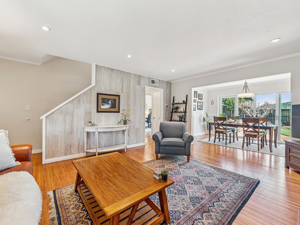 Bright living room with hardwood floors, recessed lighting and wood burning fireplace.