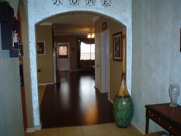 STANDING AT FRONT DOOR LOOKING INTO FOYER LEADING INTO LIVING ROOM