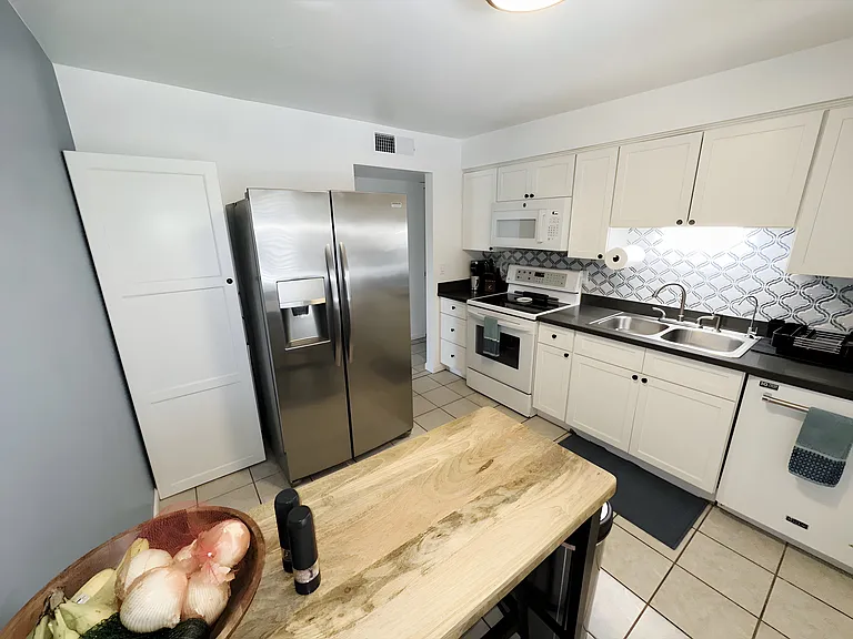 Kitchen including a dishwasher, stove, microwave, toaster, and fridge.