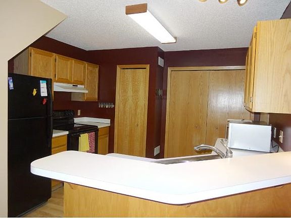 Nice kitchen with natural woodwork and breakfast bar area.
