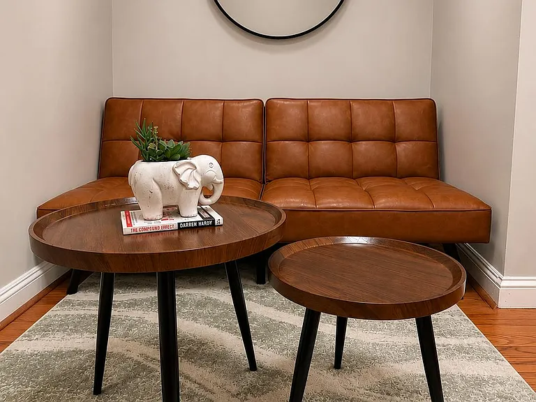 Dedicated seating nook with a leather loveseat, round coffee tables, and area rugideal for reading or relaxing.