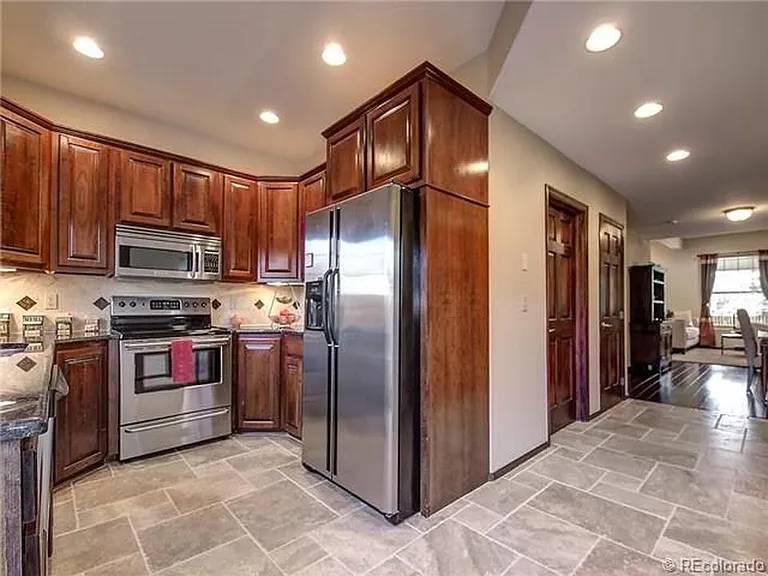 Beautiful cherry wood cabinets and travertine tile in kitchen and downstairs bathroom