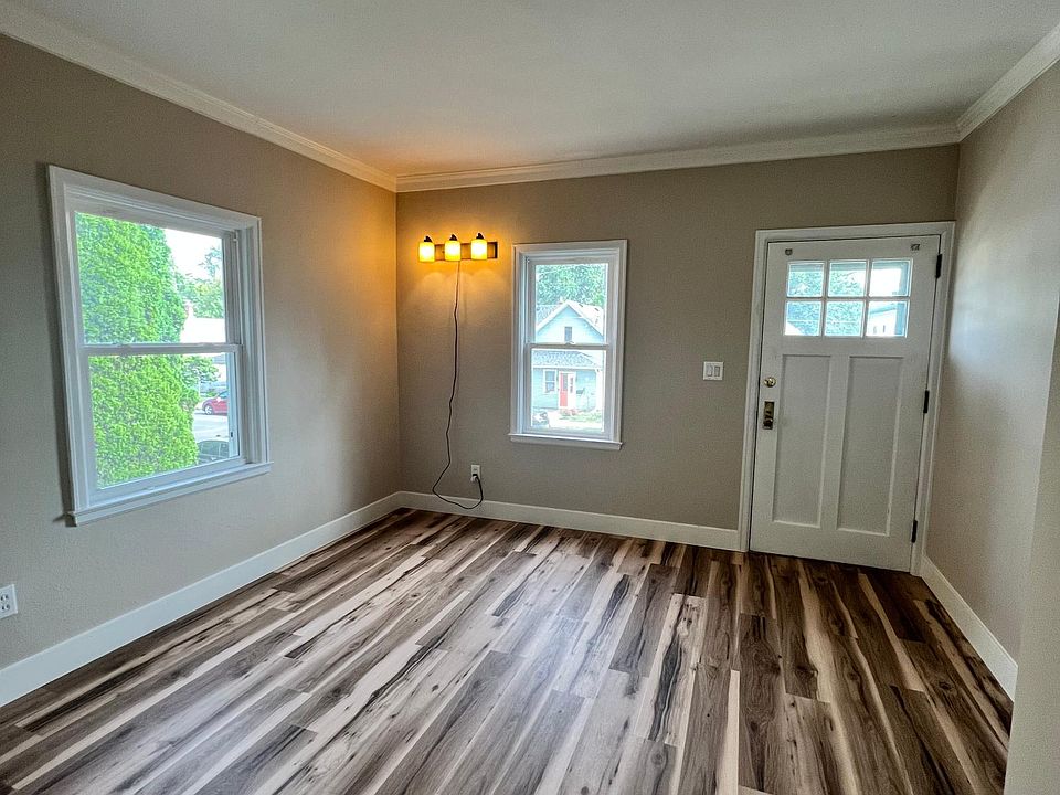 Living room with hickory vinyl plank flooring & crown molding.
