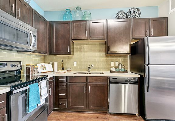Luxurious kitchen, stainless steel appliances, stunning large islands and faux wood flooring.
