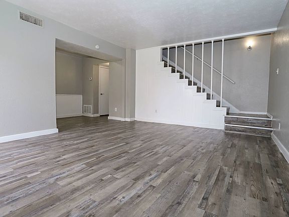 Open-concept living area with wood-style flooring and natural light throughout.