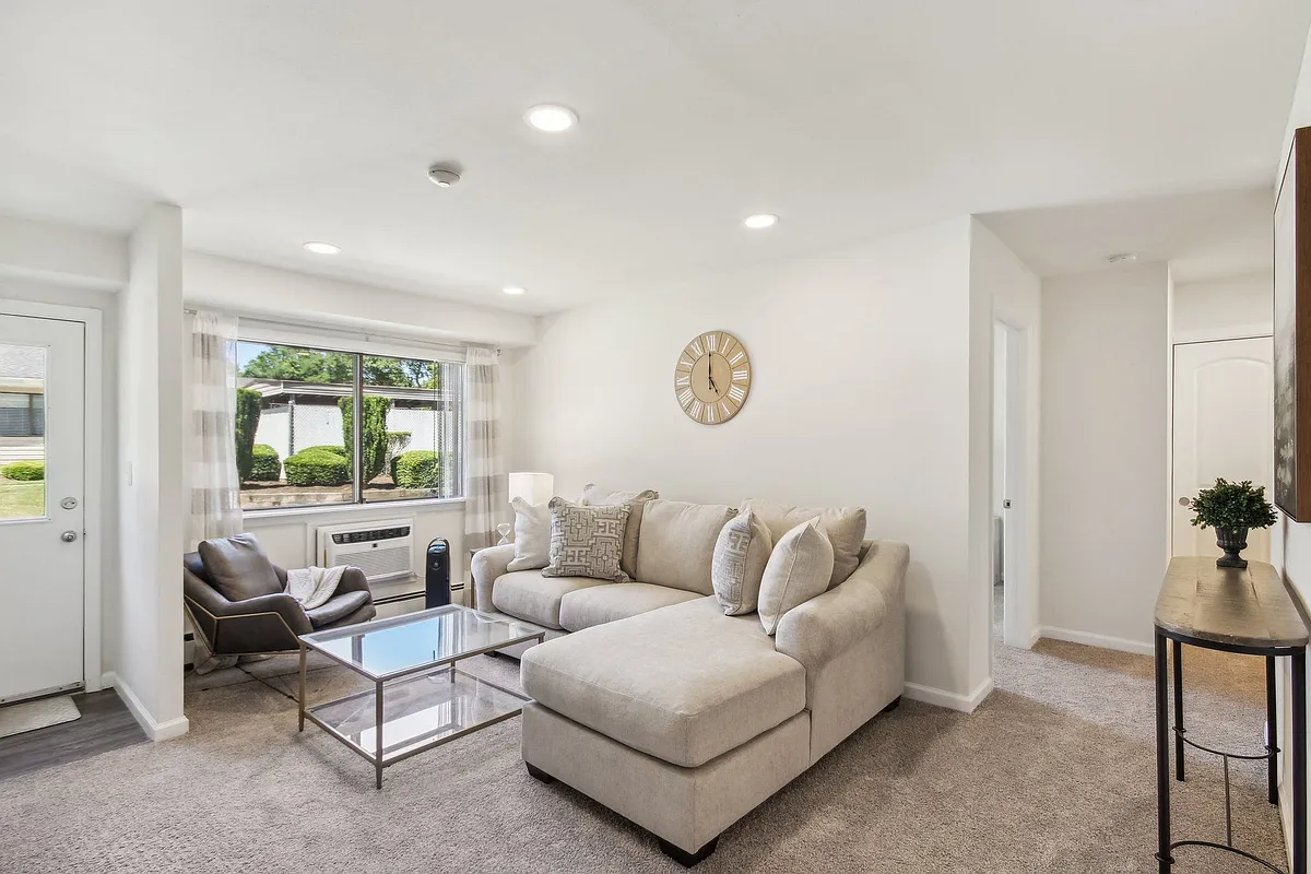 a spacious living room with a couch and a coffee table - Brookwood at Ridge
