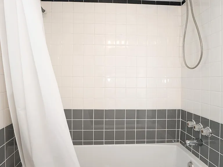 Bathtub/shower combination with tiled surround.