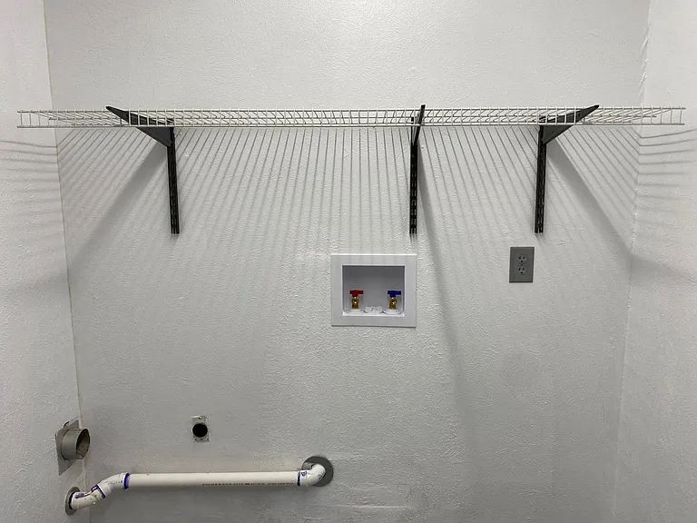Newly refreshed utility room with new washer hookups, wire shelf, fresh paint on walls and floor. Very Clean and with new bright LED lighting.