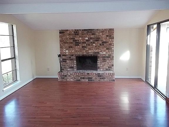large living room with fire place and wood laminate floors