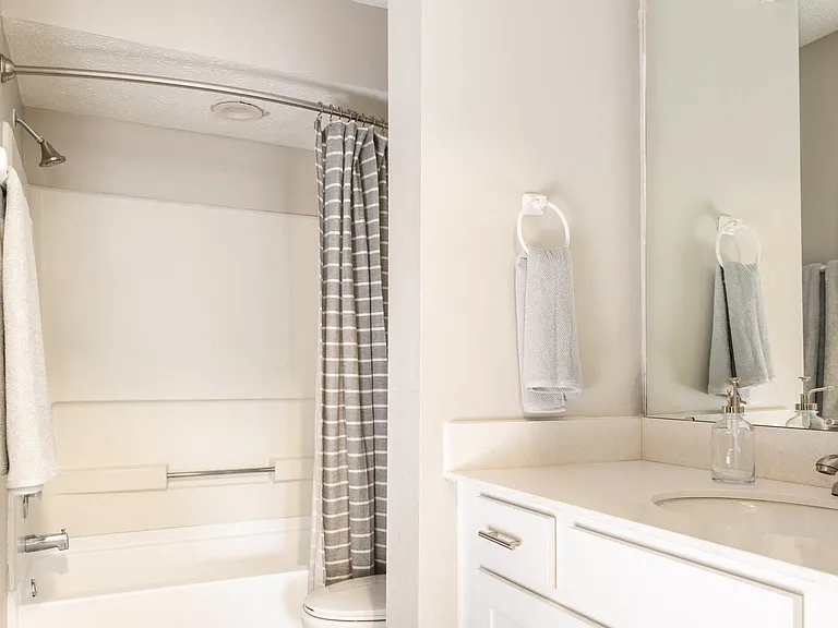 Bathrooms with Granite Countertops, Pristine White Natural Wood Cabinets, and Wood-Style Flooring