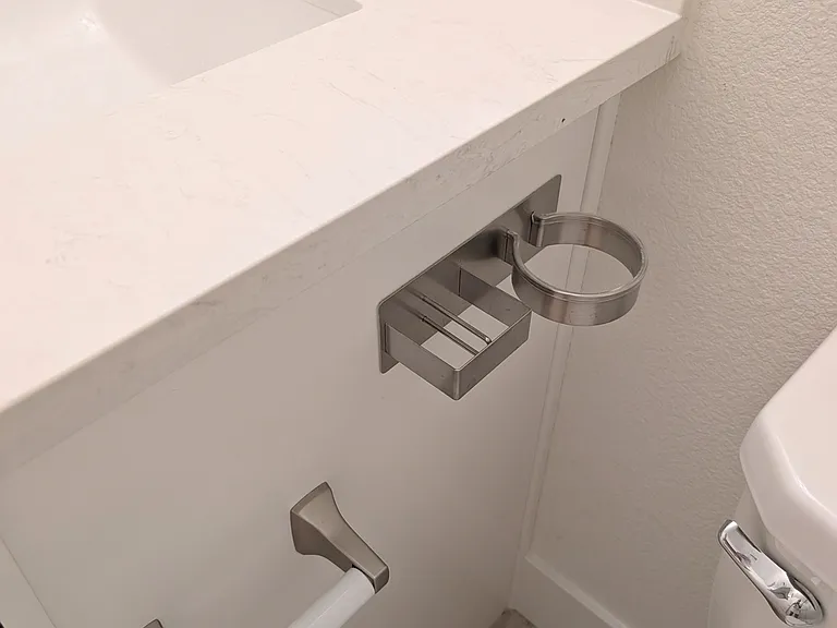 Convenient vanity-mounted hair dryer holder and styling accessory organizer, keeping your daily essentials neatly stored and easily accessible.