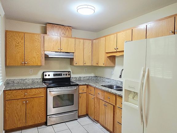 Updated kitchen with tile floor, under-mount sink, counters and newer wood cabinets