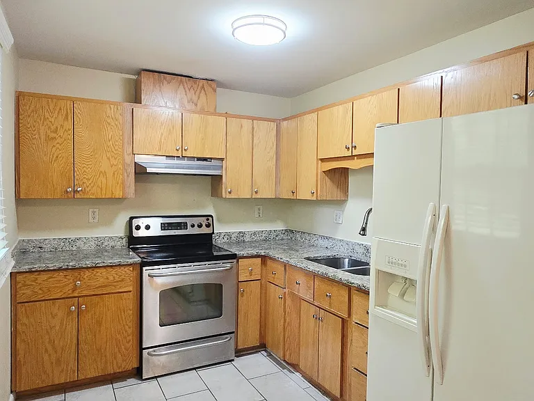 Updated kitchen with tile floor, under-mount sink, counters, and newer wood cabinets