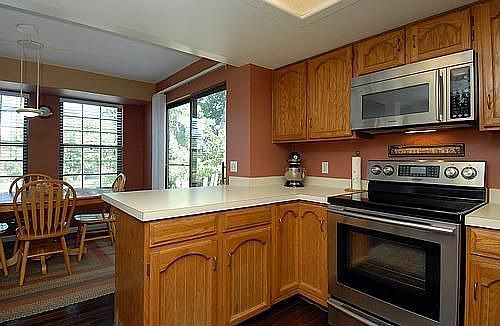 The open kitchen includes stainless steel appliances and breakfast bar.
