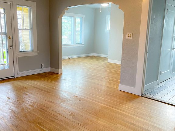 Living room with separate office space overlooking the neighborhood tree line.