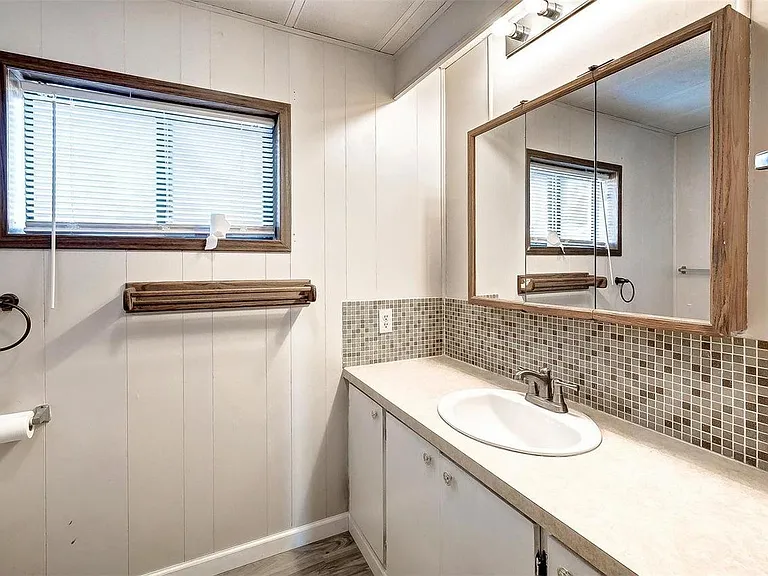 Full bathroom with toilet, sink, vanity, and bathtub/shower.