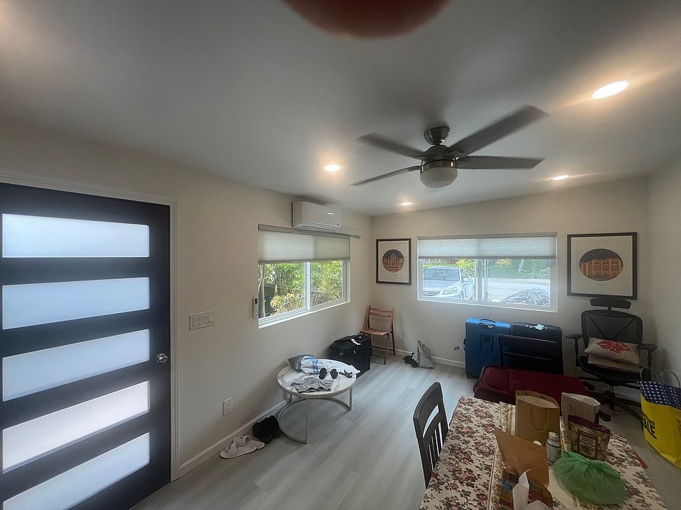 Living room with recessed lighting, ceiling fan/light and wall-mounted AC unit for cooling and heating