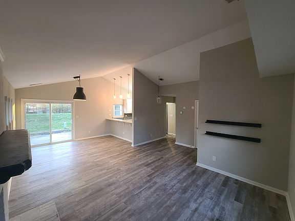 Open concept living room and dining room with bar ledge to kitchen