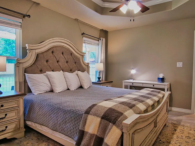 Spacious primary bedroom featuring a vaulted ceiling with ceiling fan, plus an attached bathroom and walk-in closet.