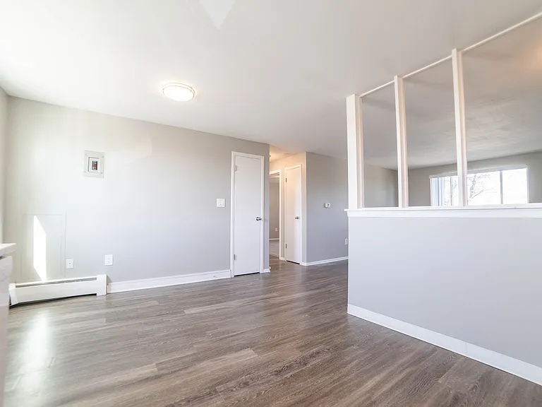 Bright and modern open-plan living area with sleek hardwood floors and ample natural light.