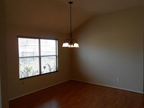 Formal Dining Room With Wood Laminate Floors & Upgraded Light Fixture.