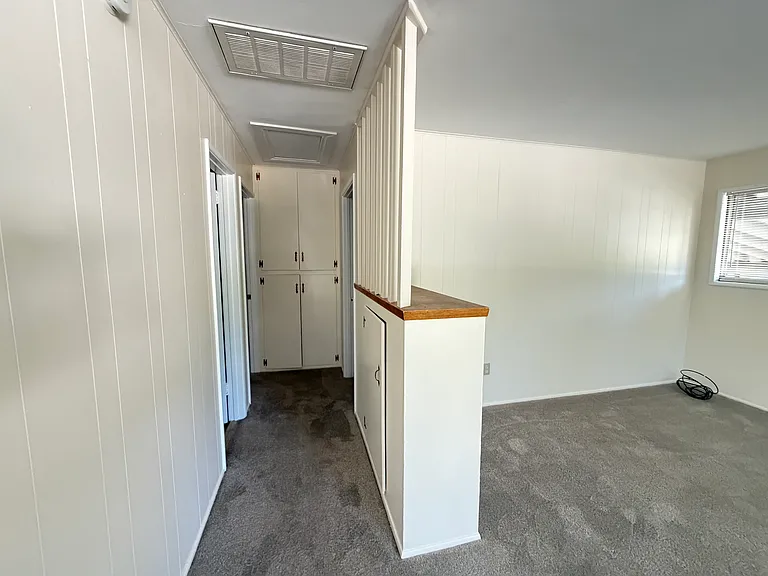 Hallway to bedrooms with linen cabinets.