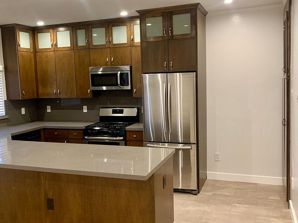 Upgraded kitchen with quartz counters, stainless steel appliances and custom cabinets