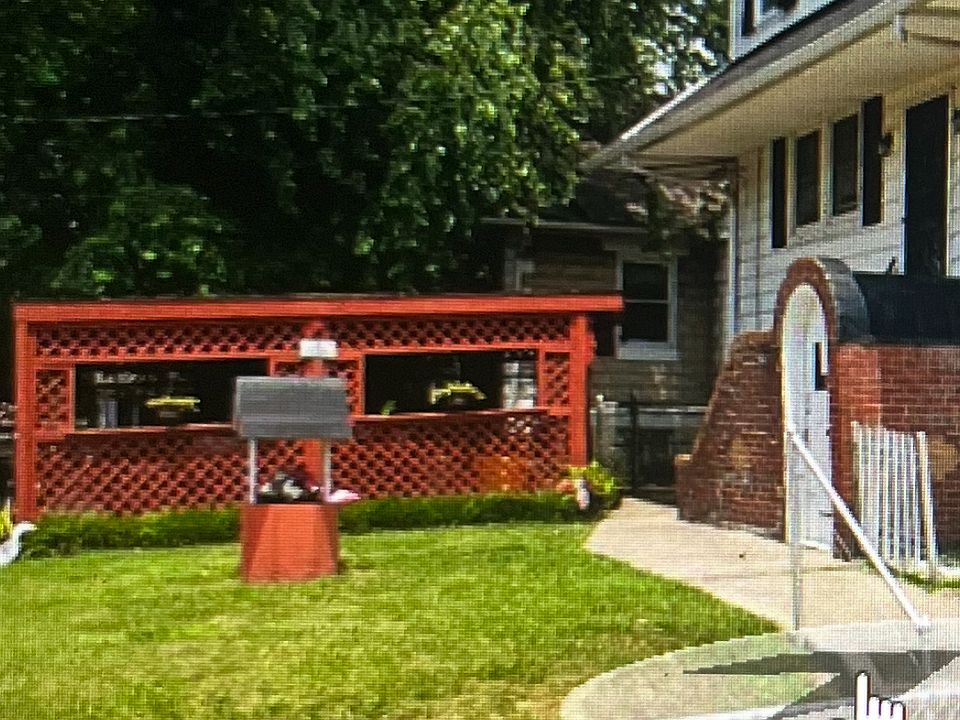 Entry is the brick arch by the sidewalk.