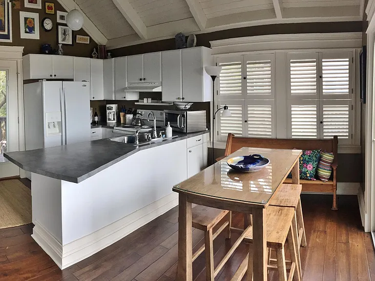Keep an eye on the marsh while preparing a meal. Gleaming hardwood floors, classic shutters and marsh-front deck to the right.