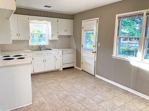 Newly tiled kitchen with built-in dishwasher.