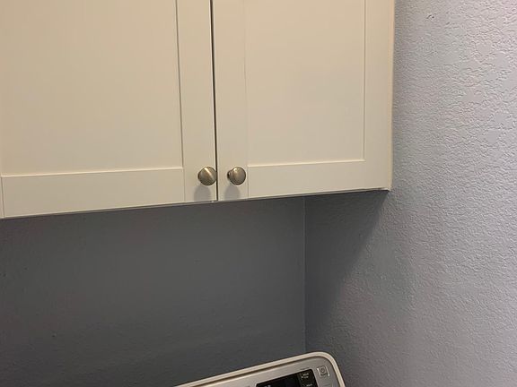 Laundry room with storage cabinets.