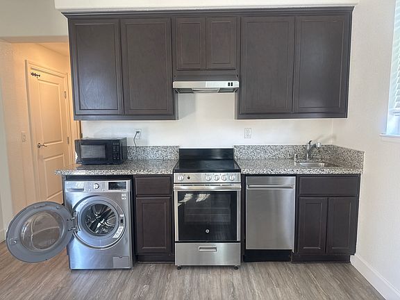 Washer-dryer combo, electric stove, and dishwasher included.
