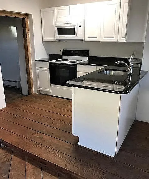 Kitchen includes refrigerator, stove, microwave and dishwasher. Ample storage space.