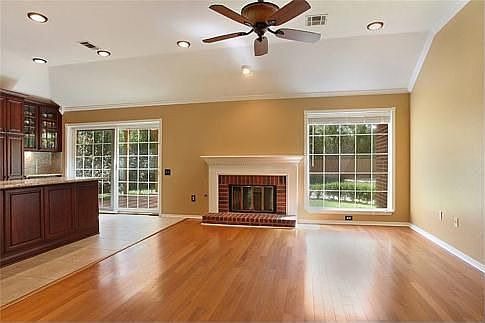 Pretty wood floors, fireplace and lots of windows in Den