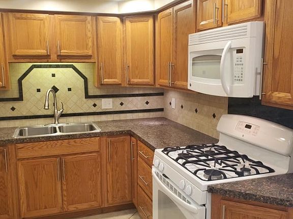 Kitchen area with gas range, built-in microwave, full custom