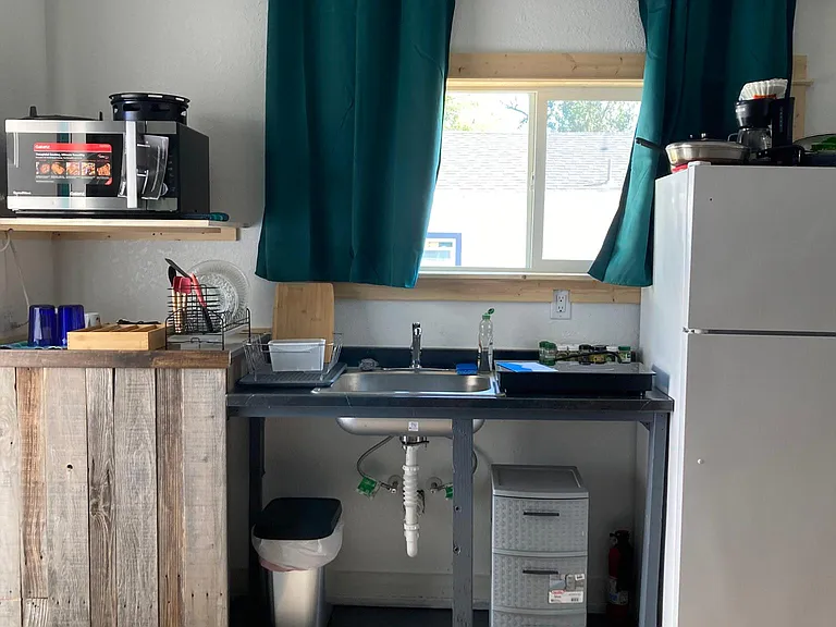 The kitchen sink is positioned nicely under a large window (there is currently a propane stove located where this refrigerator is pictured - the stove was installed after the current renter moved in, so I don't have an updated photo of that right now - th