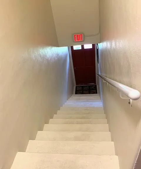 Interior building entrance stairway leading to apartment.